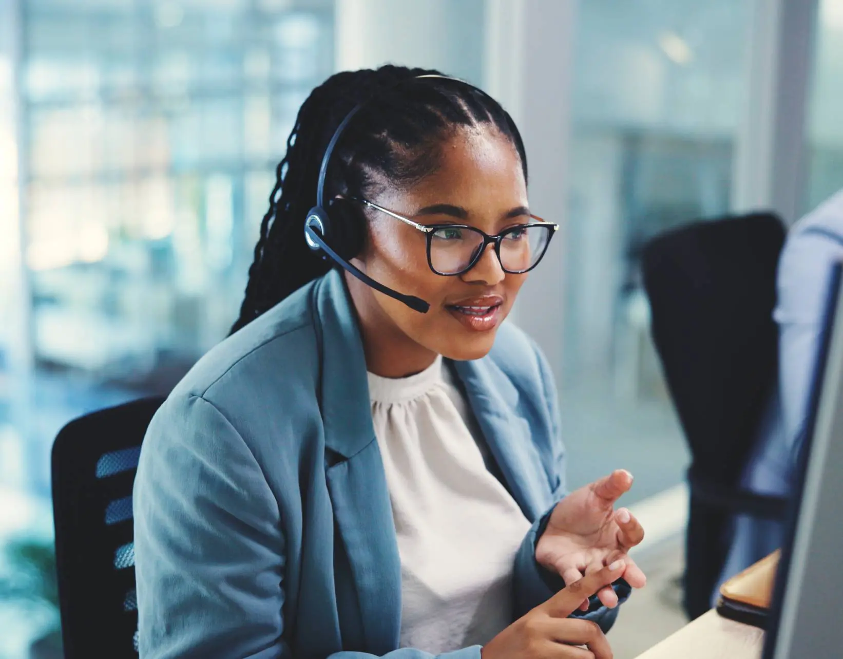 Customer service representative wearing headset at desk.