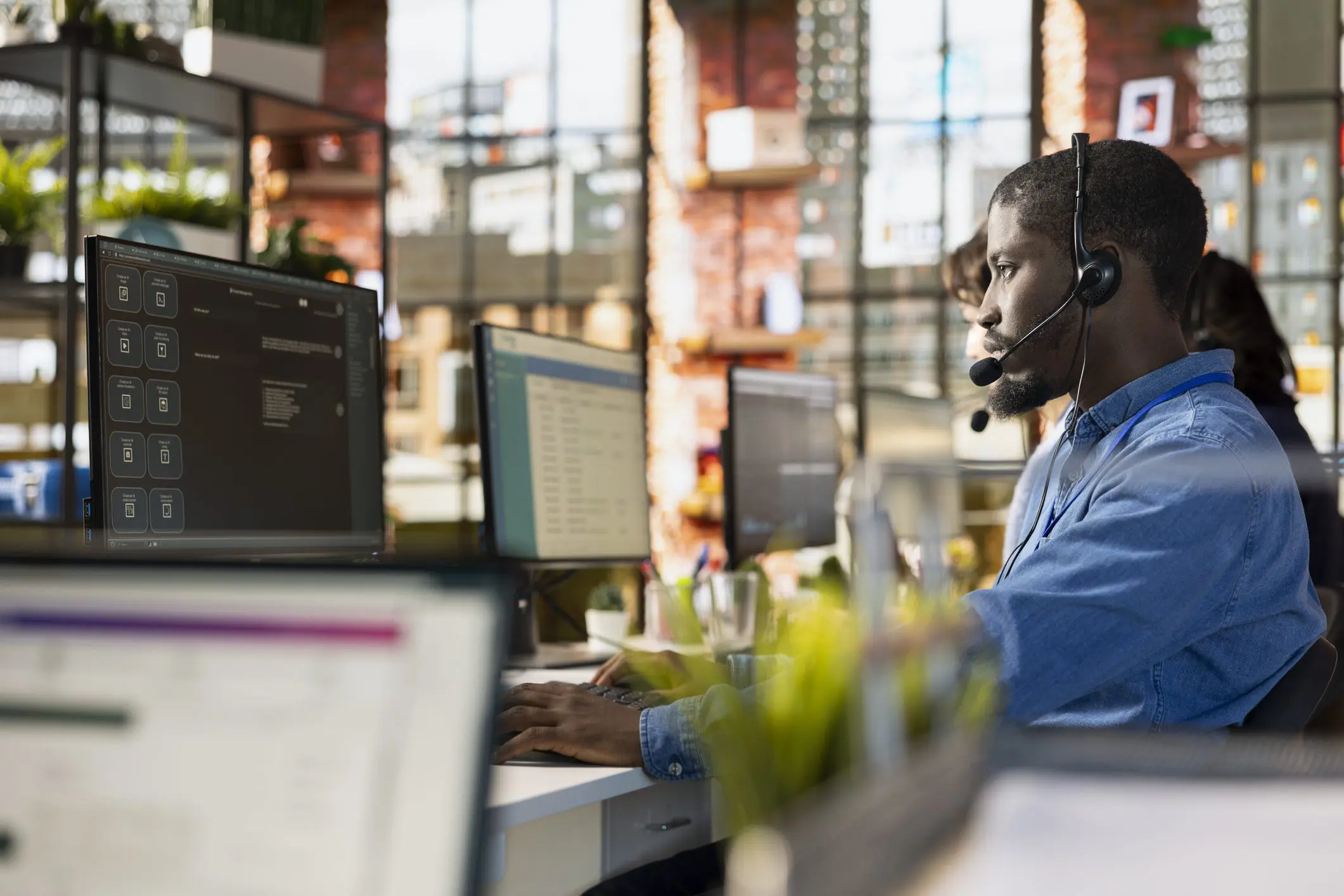Person working at computer wearing headset.