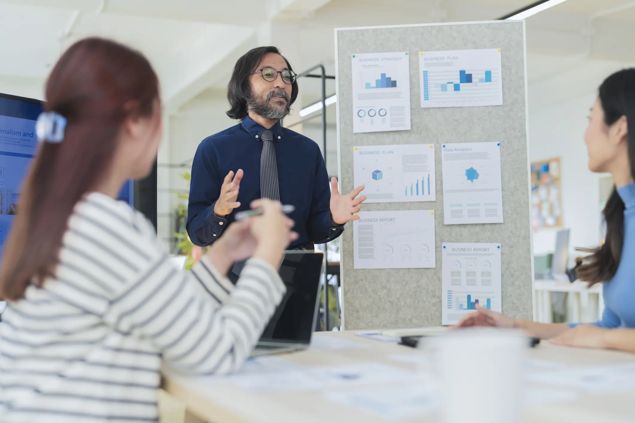 Man presenting data charts to coworkers