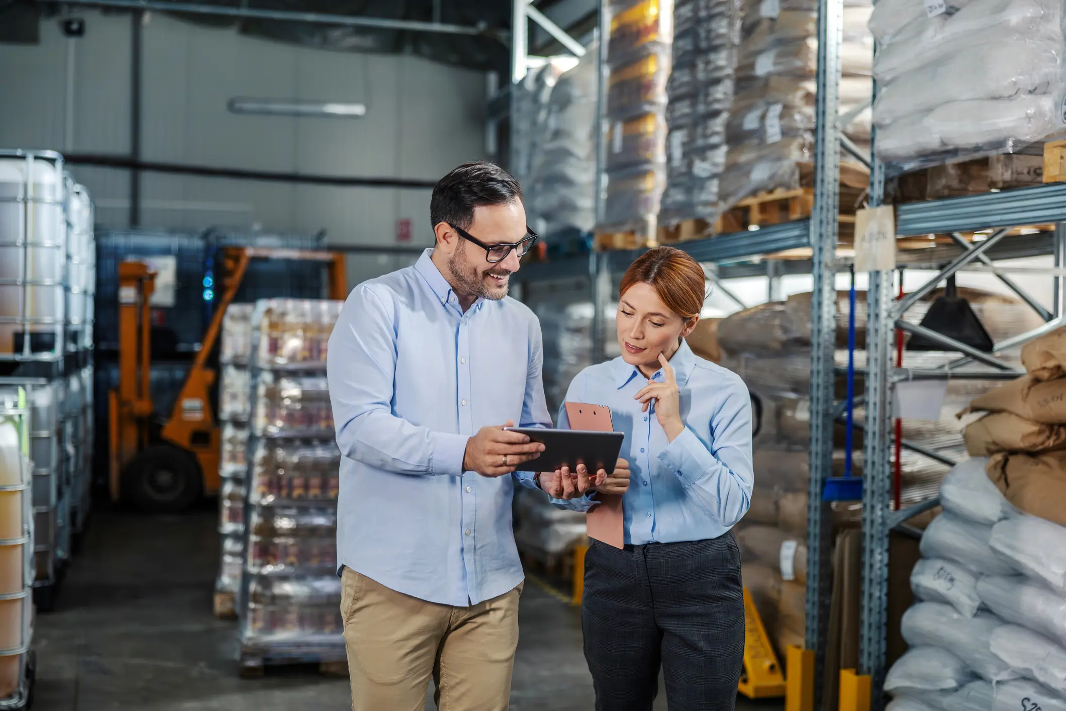 Warehouse managers reviewing inventory on tablet