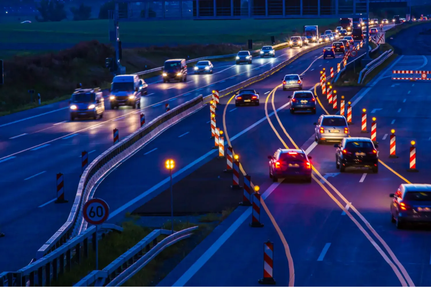 Nighttime highway traffic with construction cones