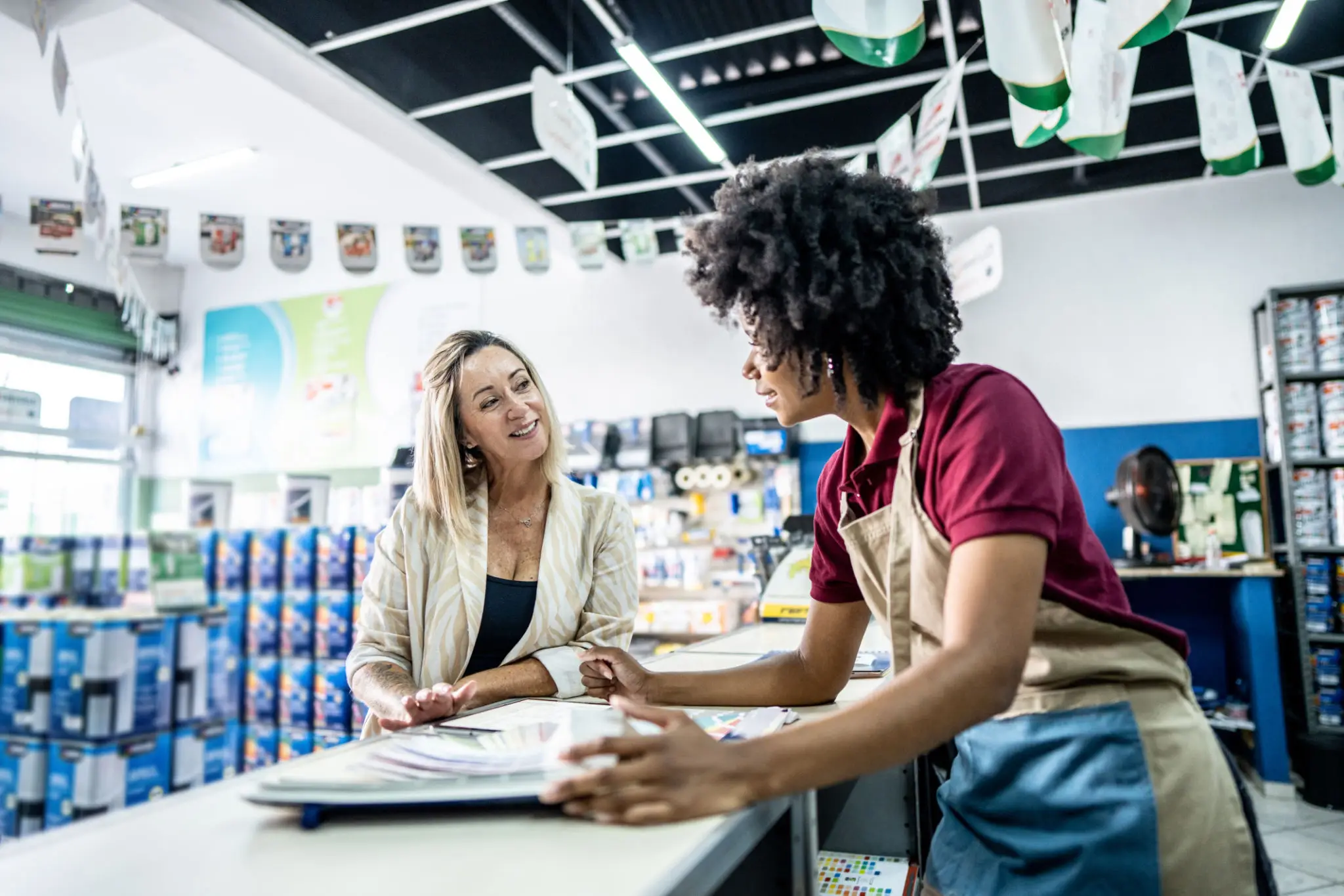 Store employee showing paint samples to customer