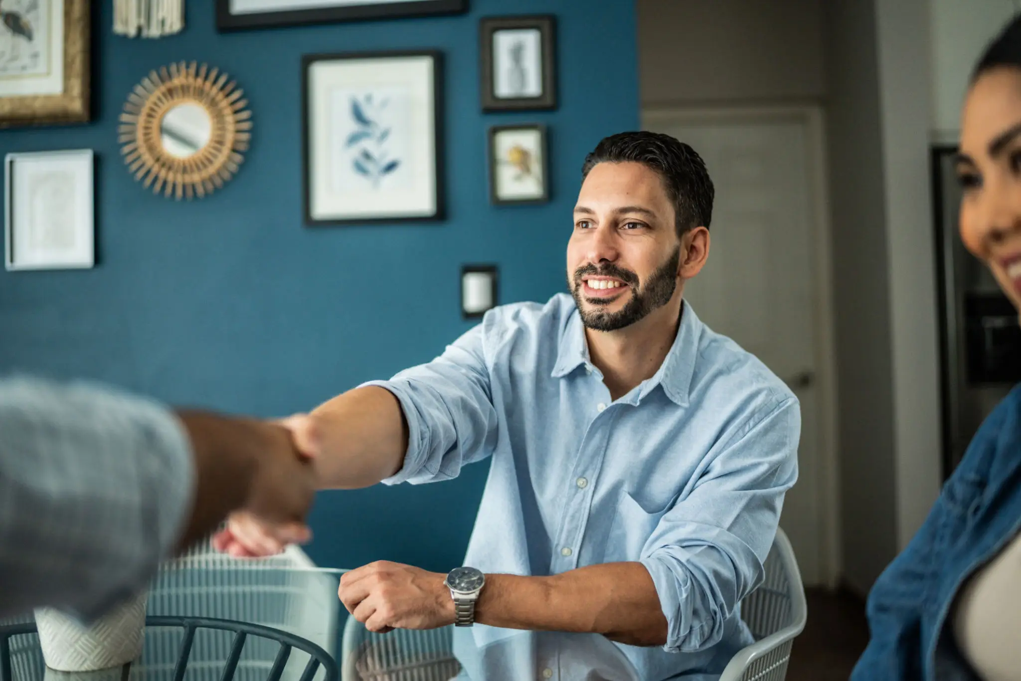 Man smiling, shaking hands in meeting